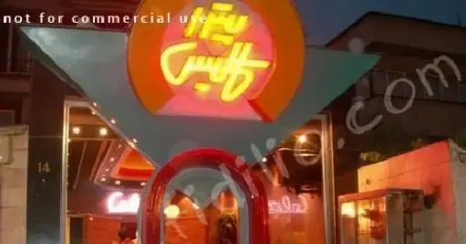 نمای بیرونی رستوران پیتزا کالیس در شب با تابلوی نئونی روشن و طرح فست فود خاص. مکانی ایده‌آل برای سفارش پیتزا.