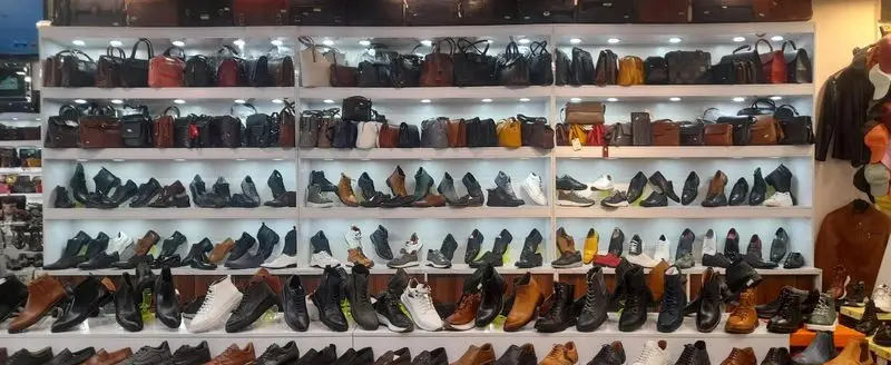 تصویری از فروشگاه هات فو پاشا با نمایش وسیع کیف‌های چرم طبیعی و کفش‌های شیک مردانه و زنانه در قفسه‌های مرتب و نورپردازی شده.