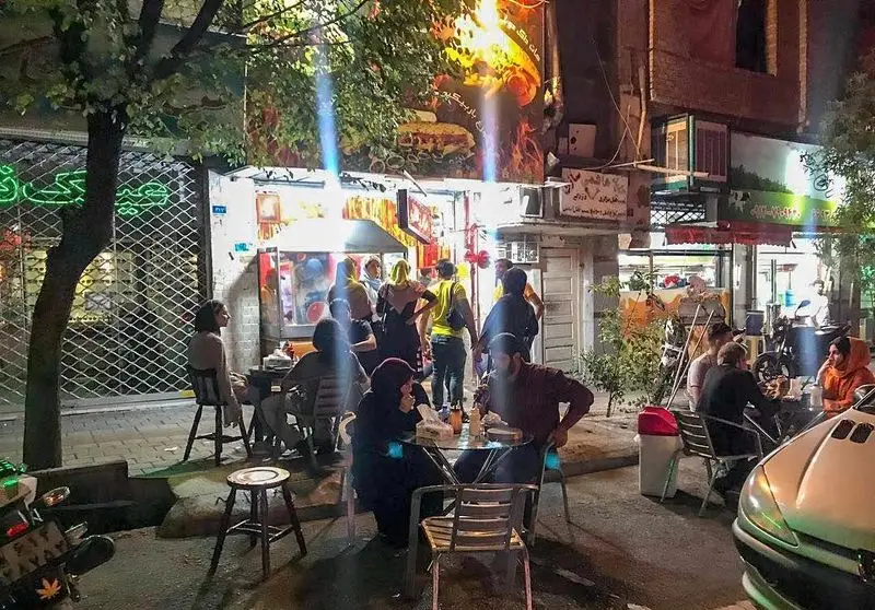 فست فود شقایق شب‌ها پررونق: مشتریان در فضای باز مشغول صرف انواع غذاهای فست فودی و لذت بردن از دورهمی در محیطی دلنشین.