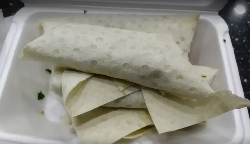 رول‌های لذیذ شاورما یا کباب ترکی بابا میرزا، تازه و آماده در ظرف سفید یکبار مصرف. مناسب برای سفارش و ارسال.