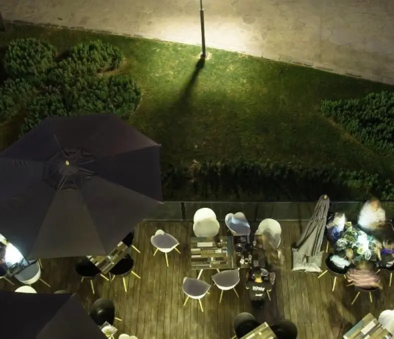 فضای باز شبانه رستوران فرنگی کوبابا از بالا، شامل دکوراسیون چوبی، میز و صندلی‌های مدرن، چترهای سایبان و محیطی آرام برای مشتریان.