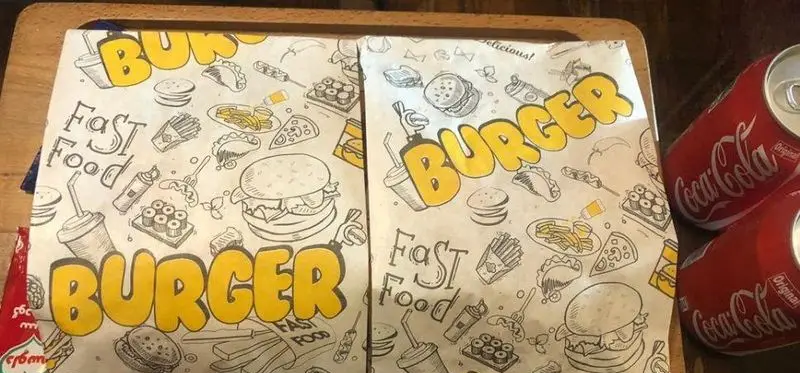 بسته بندی اختصاصی فست فود پیتزا ونوس با طرح‌های جذاب برگر، پیتزا، سیب زمینی و نوشیدنی به همراه قوطی کوکاکولا.