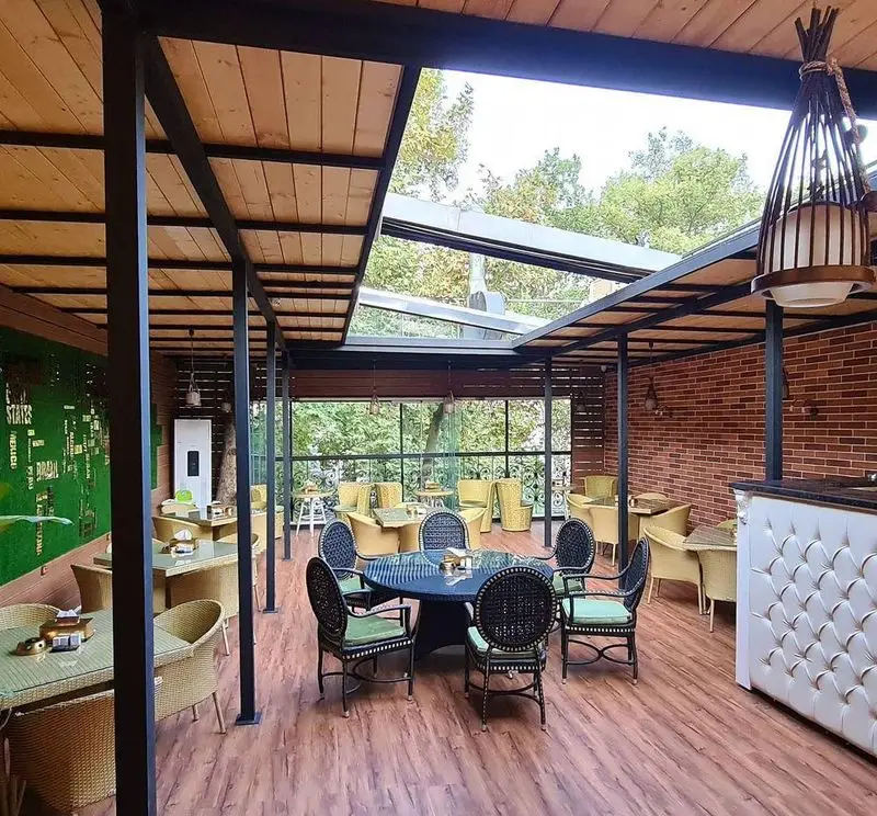 کافه سالار: فضای باز دلنشین با سقف متحرک، دکوراسیون مدرن، میز و صندلی حصیری و چشم‌انداز طبیعی. ایده‌آل برای کافه و رستوران.