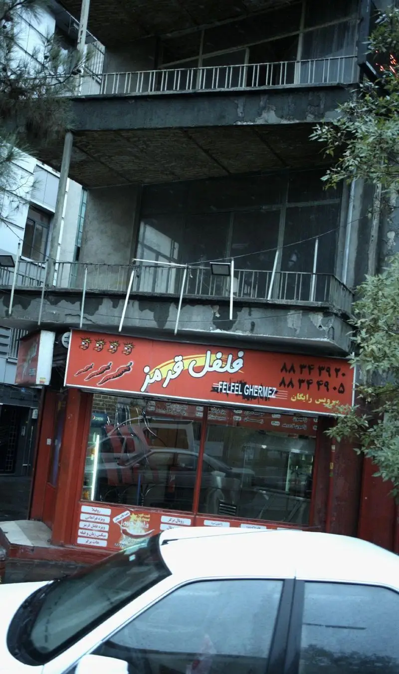 تصویر نمای بیرونی فروشگاه فلافل فلفل قرمز با تابلوی قرمز، شماره تماس ۸۸۳۴۳۹۲۰ و ۸۸۳۴۴۹۰۵ و سرویس رایگان.