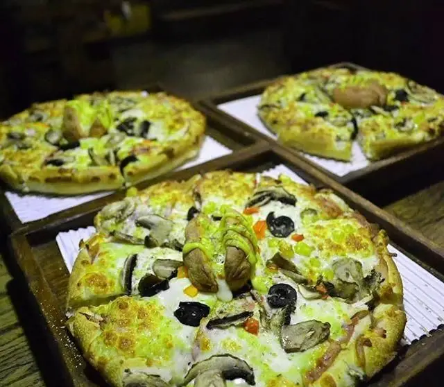 تصویری جذاب از سه پیتزای کافه بتیس، با پنیر فراوان، قارچ تازه، زیتون سیاه و فلفل سبز، آماده سرو برای مشتریان.