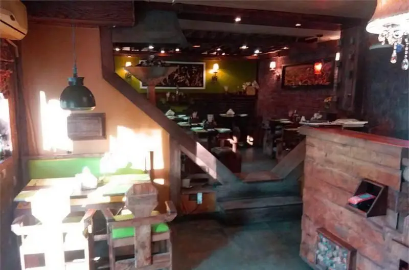 فضای داخلی کافه بتیس با دکوراسیون چوبی و سنتی، شامل میز و صندلی‌های راحت و نورپردازی دلپذیر، محیطی دنج و گرم برای مشتریان.