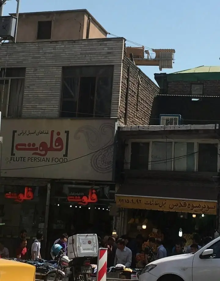 رستوران فلوت، عرضه کننده غذاهای اصیل و سنتی ایرانی، با محیطی دلنشین و مشتریان پر جنب و جوش در خیابان.