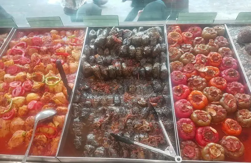 بوفه رستوران فلوت با انواع دلمه شامل دلمه فلفل رنگی، دلمه برگ مو و دلمه کلم. غذاهای سنتی و خوشمزه ایرانی.