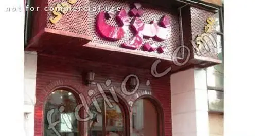 تابلوی بزرگ و نمای بیرونی جذاب ساندویچی هات داگ بیژن با حروف برجسته و ورودی قوس‌دار، یک فست فود محبوب.