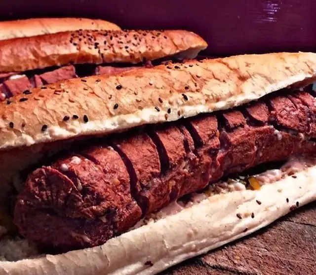 ساندویچ هات داگ بیژن؛ سوسیس با کیفیت، نان باگت برشته و کنجد، همراه با چاشنی‌های خوش‌طعم، تجربه‌ای لذیذ از فست فود.