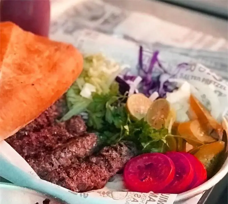 ساندویچ کباب کوبیده لذیذ فست فود دونر لکوم با نان تازه، سبزیجات معطر و ترشی های رنگارنگ. یک غذای خوشمزه و باکیفیت.