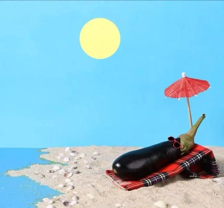 بادمجان خوشحال مستر دیزی روی شن ساحل زیر آفتاب با چتر و عینک آفتابی، لذت‌بخش مثل غذاهای تابستانی و لذیذ رستوران.