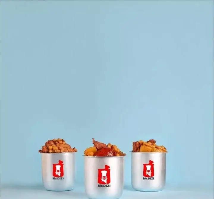 مستر دیزی: سه وعده دیزی اصیل ایرانی در ظروف آلومینیومی شیک با لوگوی قرمز برند، روی پس زمینه آبی. تجربه‌ای خاص.