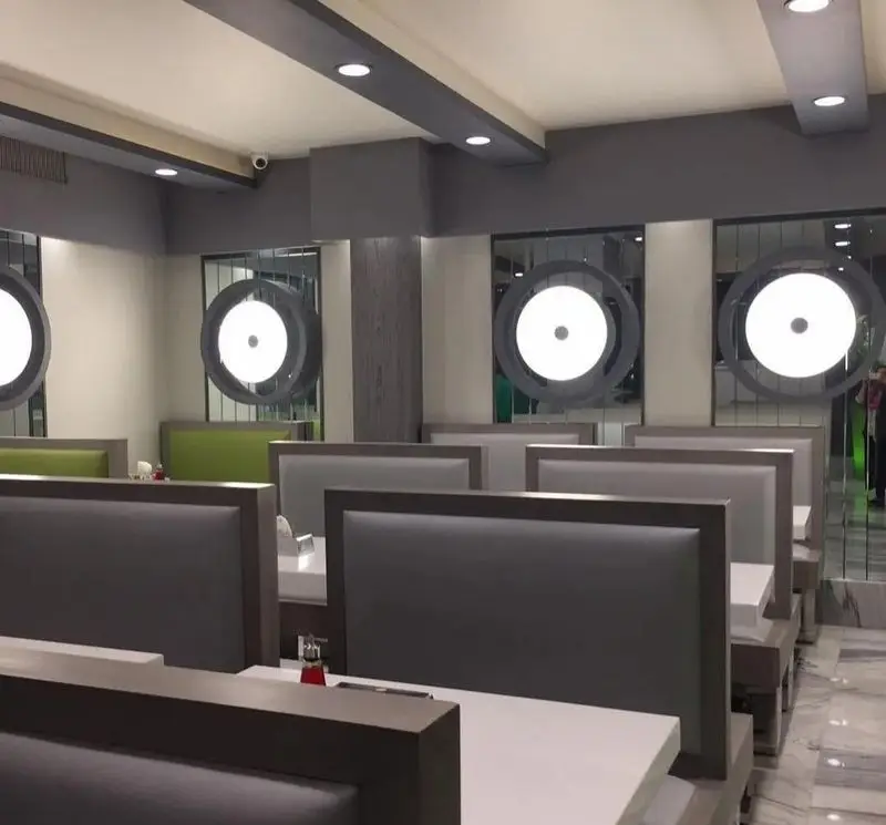 فضای داخلی شیک و مدرن پیتزا چمن با نیمکت‌های راحت و نورپردازی خاص، محیطی آرام و دلپذیر برای لذت بردن از پیتزا.