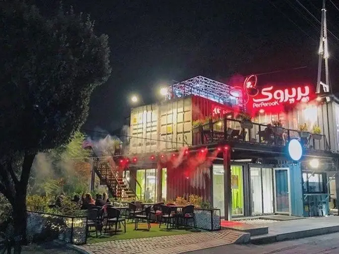 تصویری از نمای شب رستوران پیتزا پرپروک با طراحی کانتینری، فضای نشیمن باز و نورپردازی دلنشین، مکانی عالی برای غذا و دورهمی.