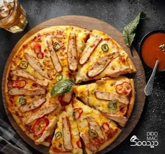 تصویر هوایی پیتزا مرغ گریل دیدومک با تکه‌های خوش‌طعم مرغ، فلفل، پنیر فراوان و سس. تجربه‌ای لذیذ از فست فود دیدومک.