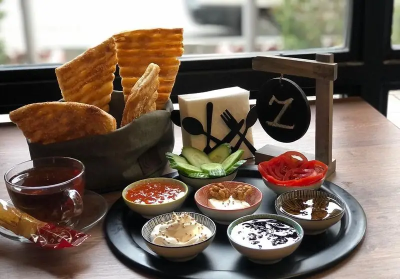 صبحانه دلپذیر در کافه و فست فود دیدومک: نان تازه، چای، مربا، پنیر، گردو، گوجه، خیار و مخلفات متنوع.