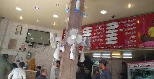 تصویری از داخل کبابسرای تک بناب با منوی کباب‌های متنوع، مشتریان و کارکنان فعال، نشان‌دهنده جو پر جنب و جوش و خوشمزه رستوران.