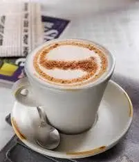 یک فنجان قهوه کاپوچینو لذیذ با طراحی هنری روی فوم، آماده سرو در کافه فنجون. تجربه طعم بی‌نظیر و کیفیت عالی را با ما.