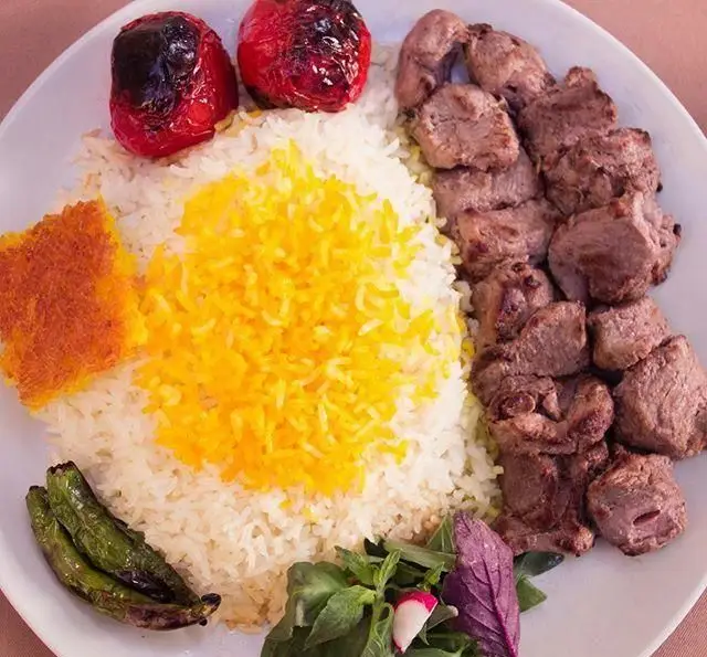 کباب چنجه رستوران چنجه همراه برنج زعفرانی، ته دیگ، گوجه کبابی و سبزی تازه. غذایی اصیل و لذیذ برای تجربه طعم ایرانی.