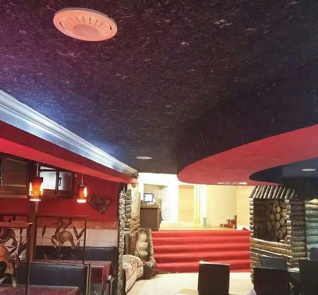 فضای داخلی دنج و شیک کافه رستوران گلایل با سقف بافت‌دار، نورپردازی گرم، میز و صندلی‌های راحت و دکوراسیون منحصربه‌فرد.