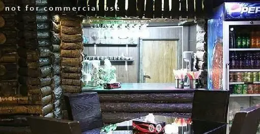 دکوراسیون داخلی کافه رستوران گلایل با طراحی چوبی و فضایی دلنشین، شامل میز و صندلی، بار نوشیدنی و یخچال پر از نوشیدنی‌ها برای مشتریان.