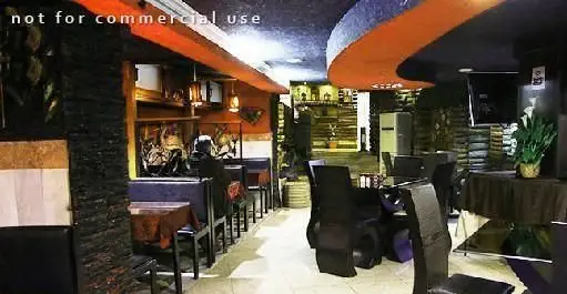 دکوراسیون داخلی کافه رستوران گلایل با میز و صندلی‌های مدرن مشکی، دیوارهای سنگی، سقف منحنی نارنجی و فضای آرامش‌بخش.