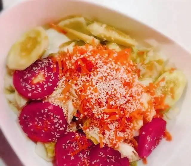 سالاد تازه و خوش‌طعم رستوران ایرانی نارنج شامل برش‌های خیار، سبزیجات قرمز، هویج رنده شده و کنجد، غذایی سالم و اشتها‌آور.