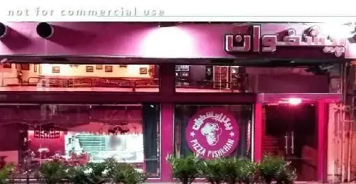 نمای بیرونی جذاب فست فود پیتزا پیشخوان در شب با رنگ صورتی روشن، تابلوی درخشان فارسی و لوگوی فیل در ورودی اصلی.