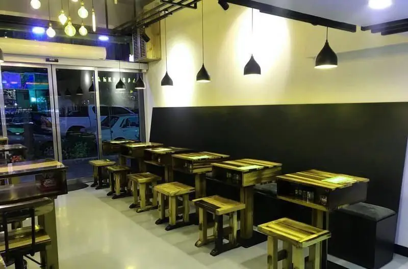 فضای داخلی رستوران ایتالیایی هورسان با میز و صندلی‌های چوبی مدرن، نورپردازی خاص و دکوراسیون صنعتی شیک برای تجربه‌ای دلپذیر.