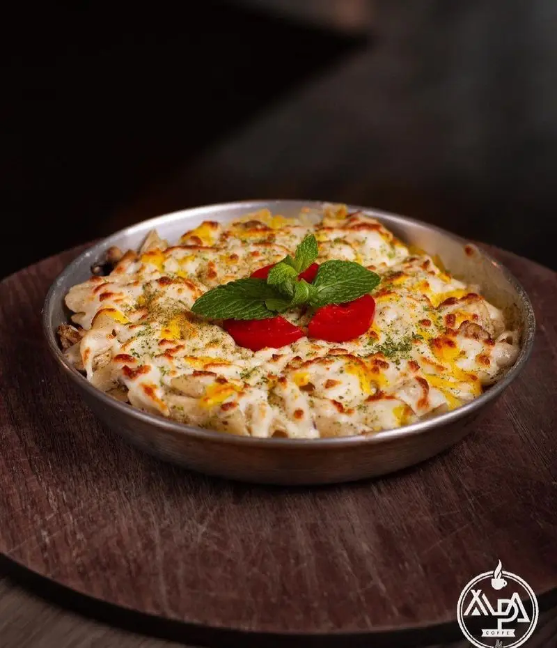 گراتن پاستا یا لازانیا با سس سفید و پنیر فراوان در کافه رستوران آلپا، یک غذای گرم و لذیذ برای تجربه شام یا ناهار دلپذیر.