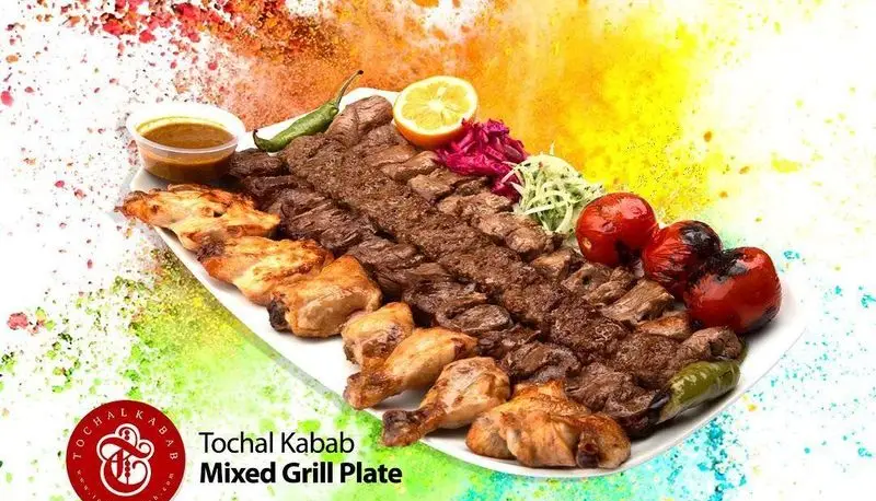 سینی میکس گریل لذیذ کباب سرای توچال با انواع کباب کوبیده، جوجه کباب، کباب برگ و چنجه، همراه با گوجه کبابی، فلفل و لیمو. غذای اصیل ایرانی.