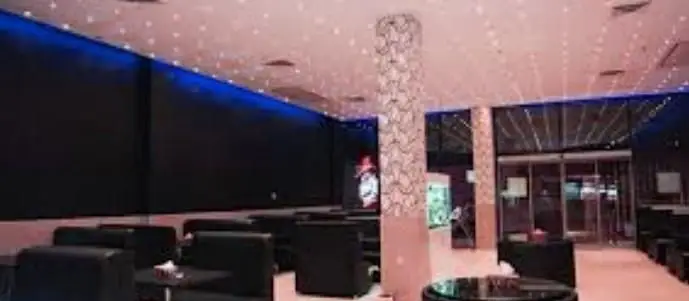 تصویری از سالن غذاخوری پیتزا هات با دکوراسیون داخلی لوکس، صندلی‌های راحت مشکی و نورپردازی جذاب سقف برای تجربه خاص مشتریان.