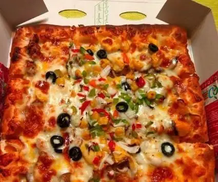 پیتزای مستطیلی و خوشمزه پیتزا هات با تاپینگ‌های رنگارنگ سبزیجات، زیتون، ذرت، فلفل دلمه‌ای و پنیر آب شده.