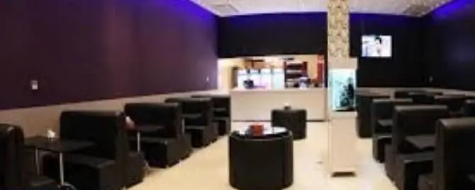 تصویری از فضای داخلی پیتزا هات با طراحی مدرن، شامل میز و صندلی‌های راحت و پیشخوان خدمات، مناسب برای یک تجربه غذایی دلپذیر.