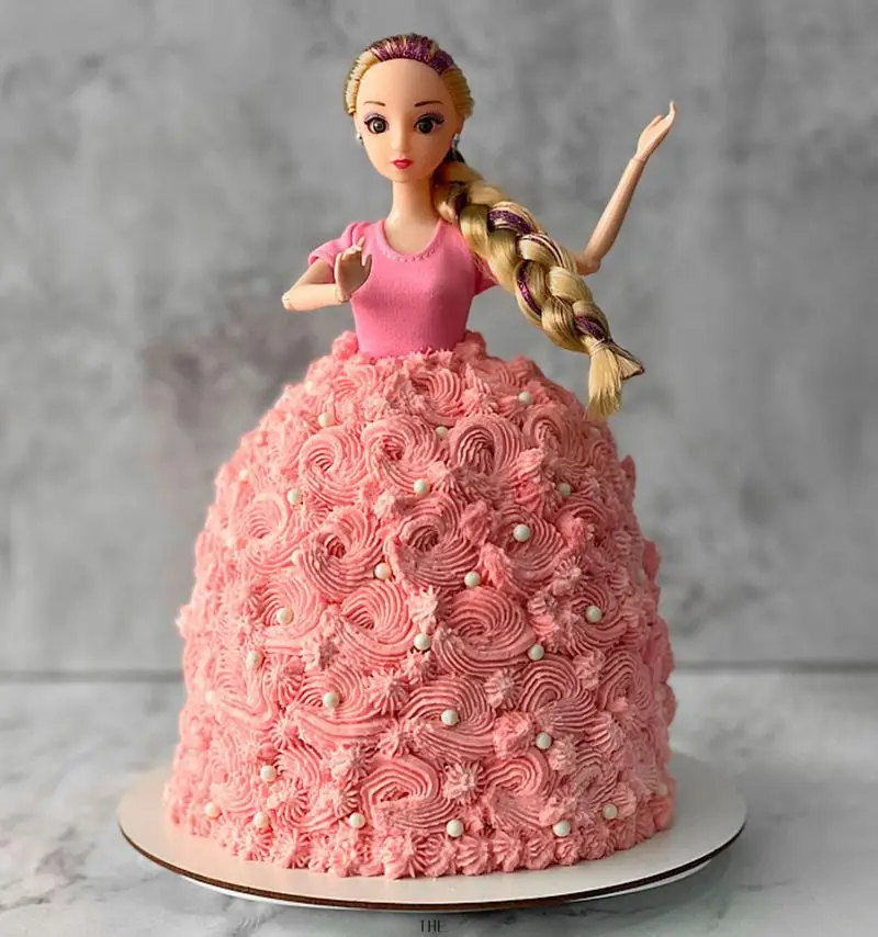 کیک عروسکی پرنسسی صورتی از میس کیک، مناسب سفارش آنلاین کیک تولد دخترانه با تزیینات خامه فرم گرفته و مرواریدهای سفید.