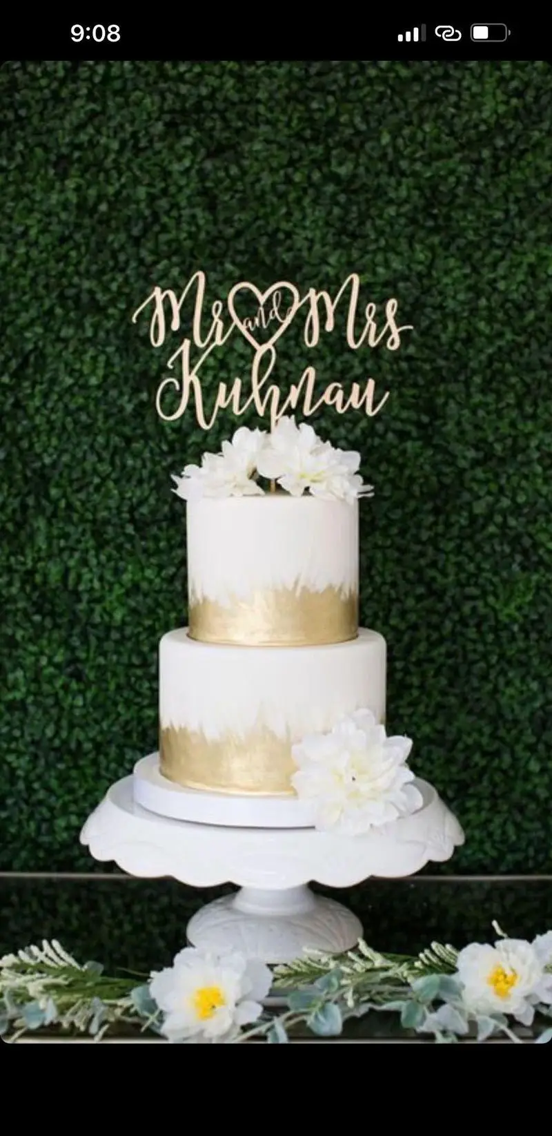 کیک عروسی دو طبقه میس کیک، با طراحی سفید و طلایی خاص و گل های شیک. بهترین انتخاب برای سفارش کیک جشن و مناسبت های شما.