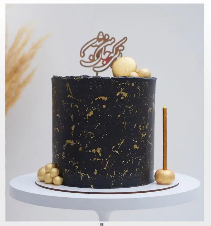 کیک تولد مشکی و طلایی لاکچری از میس کیک، با تزیینات گلد اسپلش، تاپر فارسی و کندل طلایی. سفارش کیک و شیرینی.