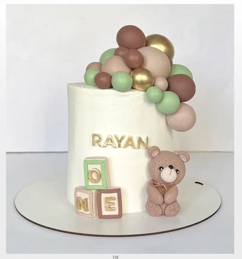 کیک تولد پسرانه یک سالگی رایان با تم خرس تدی و بادکنک‌های رنگی، طراحی زیبا و فوندانت حرفه‌ای از میس کیک. سفارش کیک کودک.