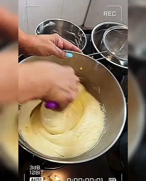 مخلوط کردن مواد کیک تازه در کاسه بزرگ برای سفارشات میس کیک، تضمین کیفیت و طعم بی‌نظیر در پخت کیک و شیرینی.