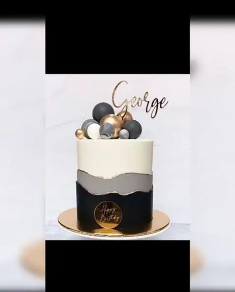کیک تولد خاص و مدرن مردانه از میس کیک، با رنگهای مشکی، طوسی و طلایی، تزیینات شیک و تاپر اسم George. سفارش کیک لاکچری.