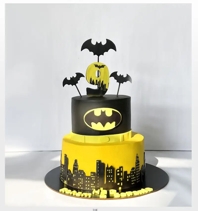 کیک تولد دو طبقه بتمن برای جشن ۹ سالگی، با تم گاتهام و لوگوی بتمن. سفارش کیک تولد خاص از میس کیک با طرح سیاه و زرد.