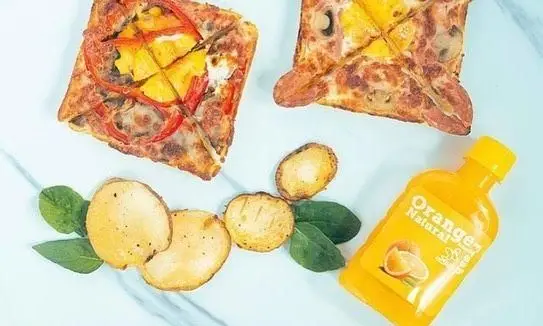 پیتزا پرپروک مربعی با فلفل، آناناس، قارچ، سیب زمینی برشته و اسفناج، همراه آب پرتقال طبیعی؛ وعده کامل پرپروک.