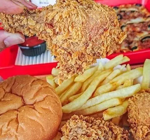 مرغ سوخاری کریسپی در کنار سیب‌زمینی سرخ کرده طلایی، نان ساندویچ و پیتزا پرپروک، نمایی از منوی فست فود.