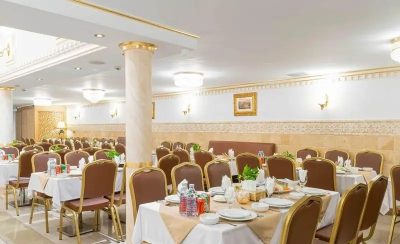 فضای داخلی وسیع رستوران باباخانی با دکوراسیون شیک، میزهای آماده سرو غذا و صندلی‌های راحت، مناسب برای پذیرایی خانوادگی و مراسم