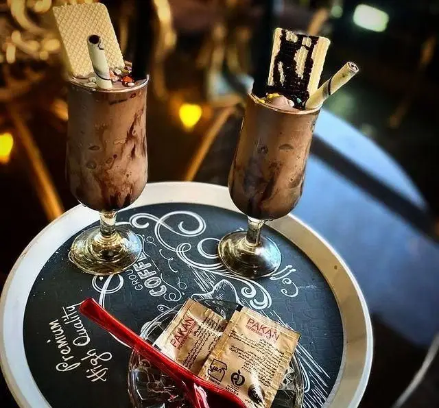 دو لیوان شیک شکلات یا آیس کافی جذاب و خوشمزه در کافه و کافی شاپ عمارت. تجربه‌ای لذیذ در محیطی دلنشین برای مشتریان رستوران عمارت.