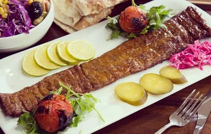 کباب کوبیده لذیذ کبابی صحرا با گوجه کبابی، لیموی تازه، خیارشور، کلم بنفش و سالاد فصل، غذای اصیل و دلپذیر ایرانی.