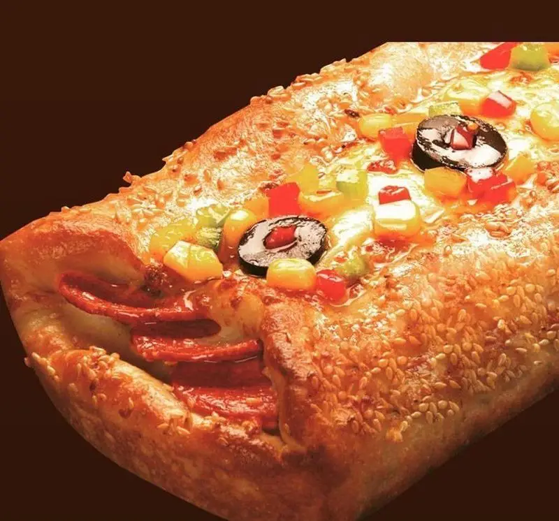 پیتزا شب: پیتزا پپرونی با نان کنجدی طلایی و مخلفات رنگارنگ، شامل زیتون، ذرت و فلفل دلمه‌ای. غذایی داغ و خوشمزه.