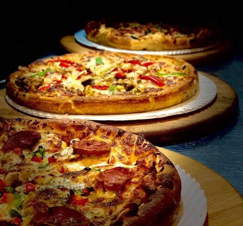 پیتزاهای لذیذ و متنوع "پیتزا شب" شامل پپرونی، مرغ و سبزیجات تازه، چیدمان سه گانه آماده سرو، باکیفیت و خوش‌رنگ.