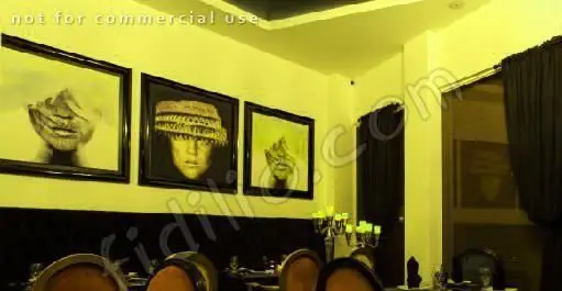 فضای داخلی لوکس و آرامش‌بخش کافی شاپ پارادیزو با تابلوهای هنری خاص، مبلمان شیک و نورپردازی گرم، مناسب دورهمی‌ها و قرارهای دوستانه